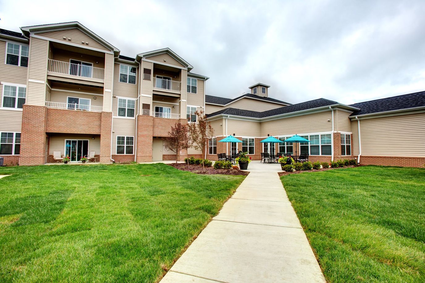 Exterior view of a senior living facility with green lawn