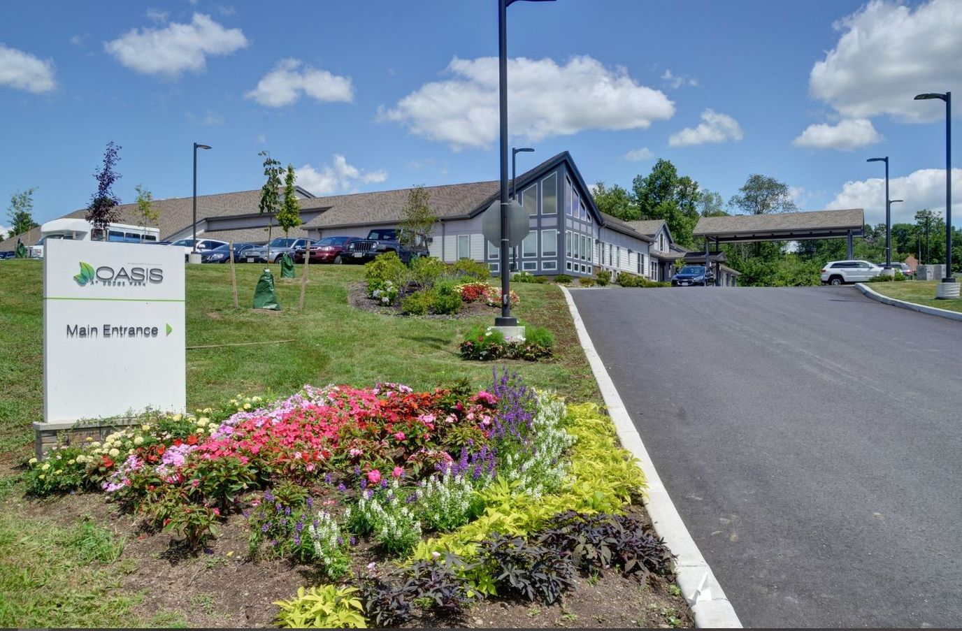 Main entrance of The Oasis at Dodge Park with flowers