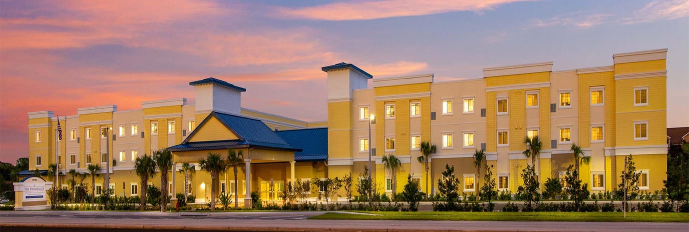 Exterior view of a senior living facility at sunset