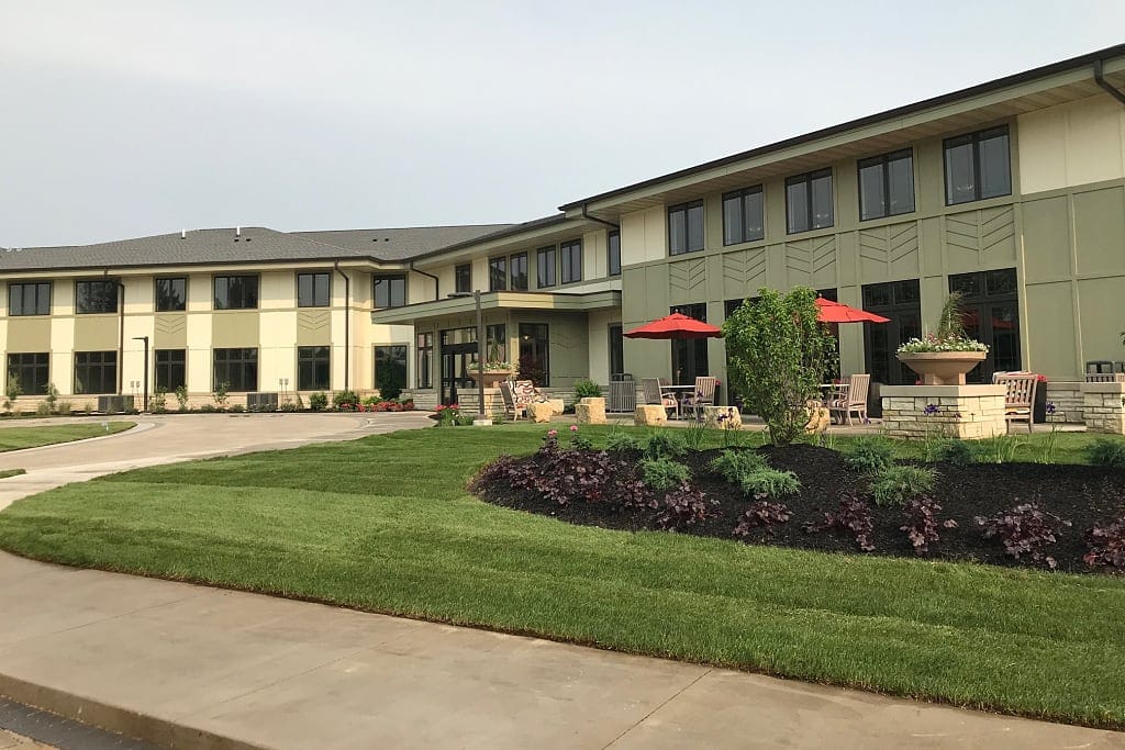 Exterior view of a senior living facility with seating areas