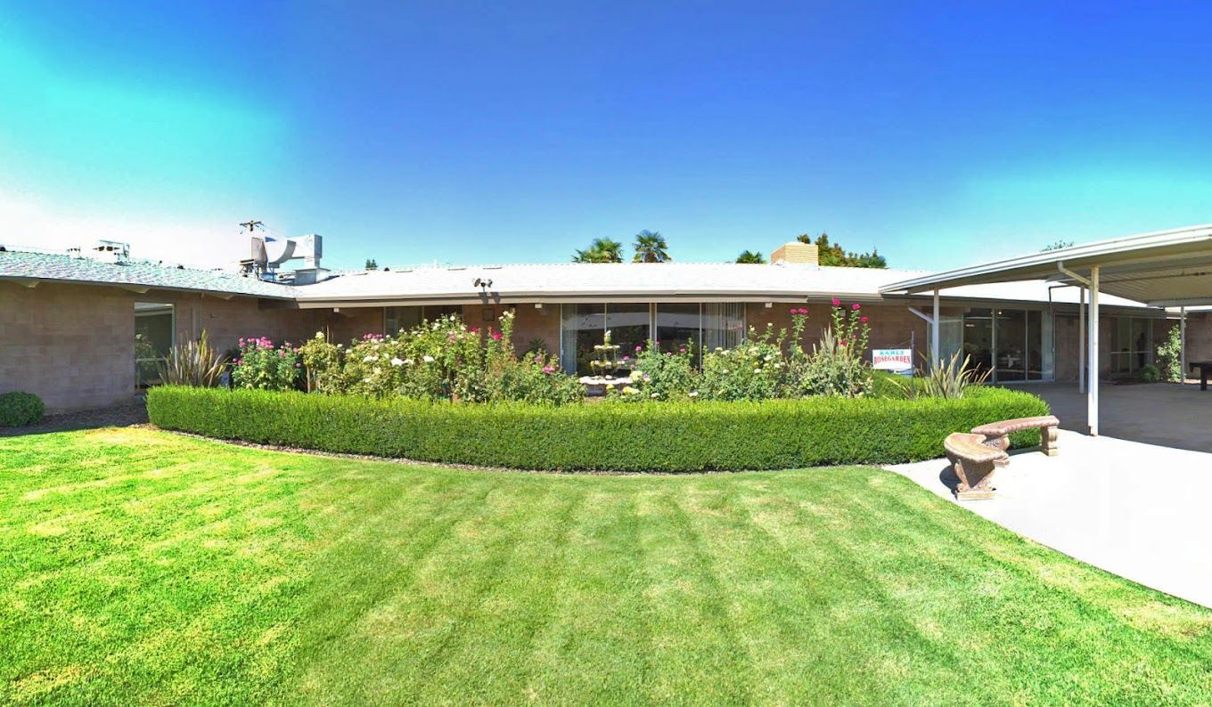 Exterior view of a senior living facility with gardens