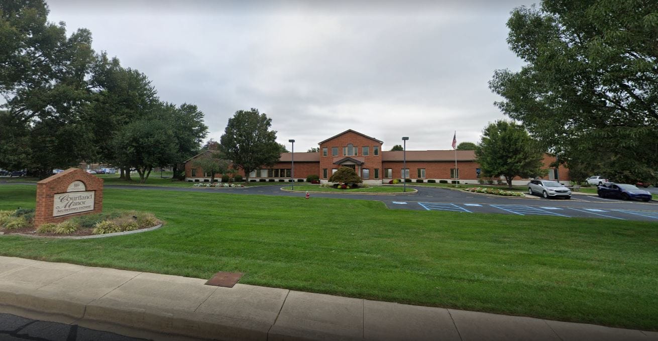 Exterior view of Courtland Manor facility with landscaped grounds