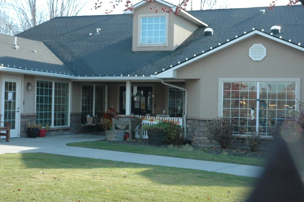 The entrance of The Cottages at Meridian with walkways and flower beds.