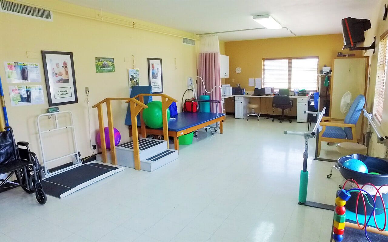 Therapy room with exercise equipment and colorful balls.