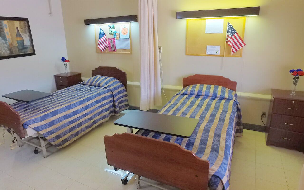 Two hospital beds in a shared room with decorations.