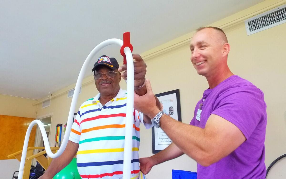 Senior resident engaged in activity with staff member