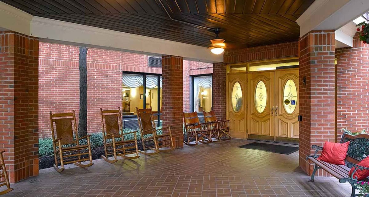 Covered entrance with rocking chairs and foyer area