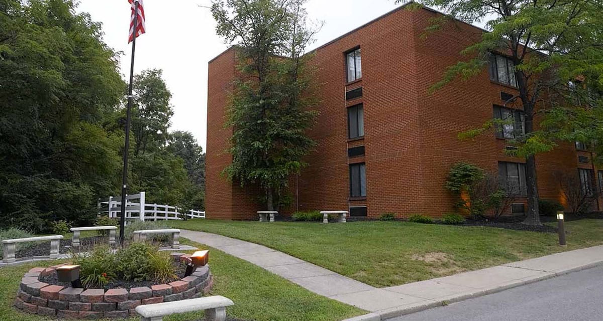 Exterior view of a senior living facility with gardens