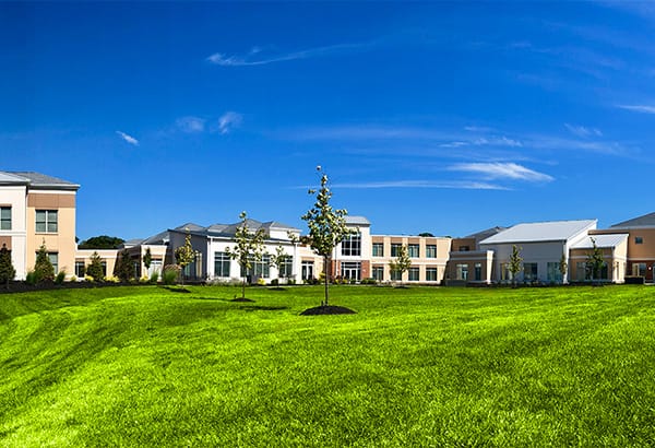 Exterior view of a senior living facility and lawn