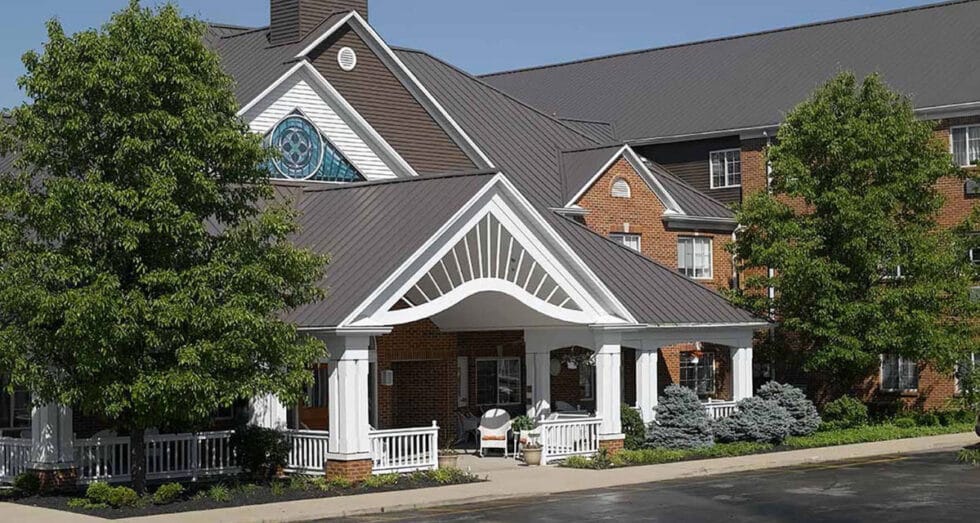 Front entrance of a senior living facility with greenery