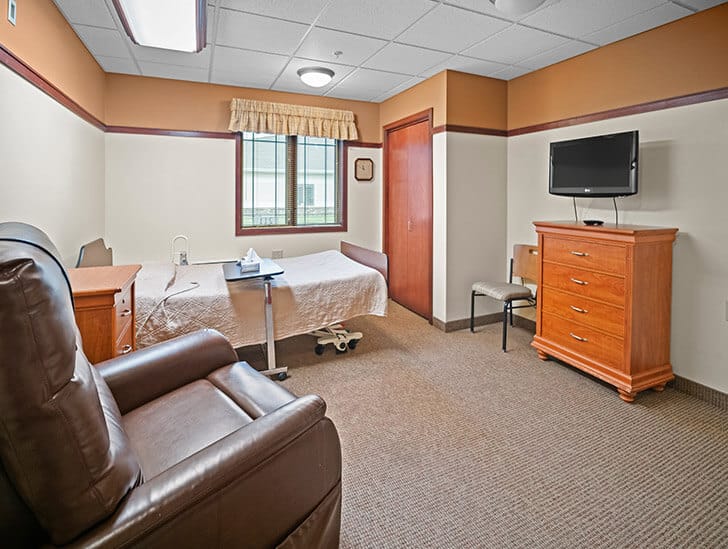 Good Samaritan Society – Grand Island Village, Nursing Home in Grand Island, NE — Cozy senior living room with bed and furniture
