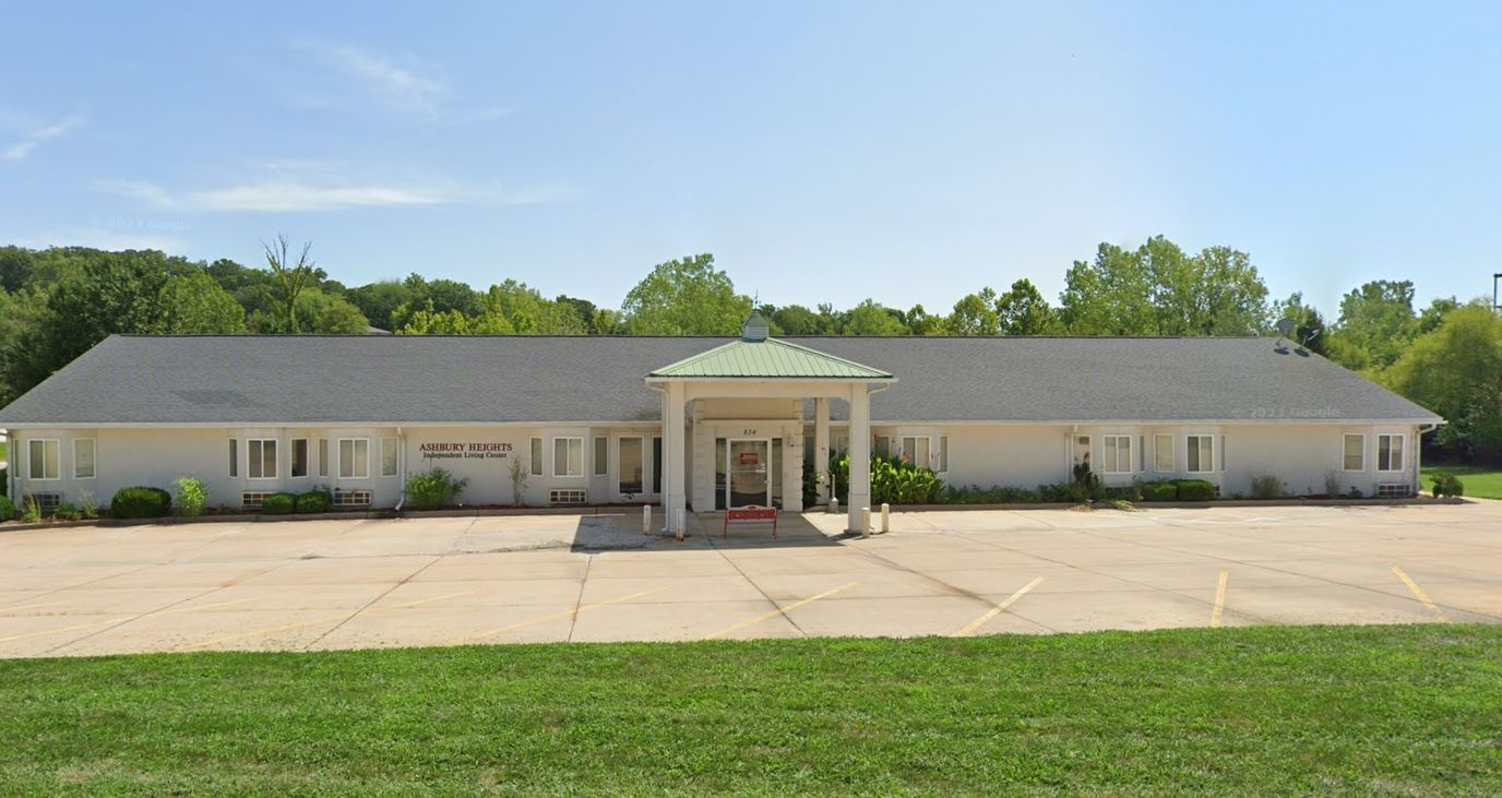 Front view of a senior living facility with lush green surroundings