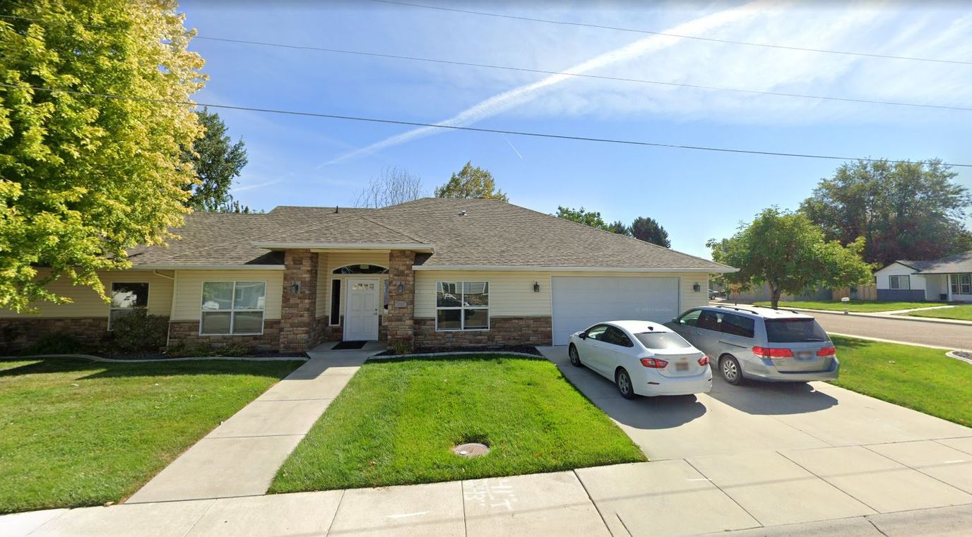 Front view of a nursing home with cars parked