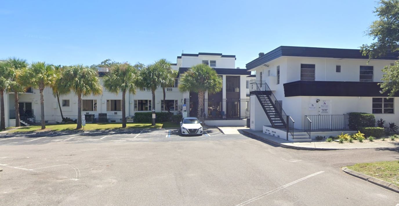 Exterior view of a senior living facility with palm trees