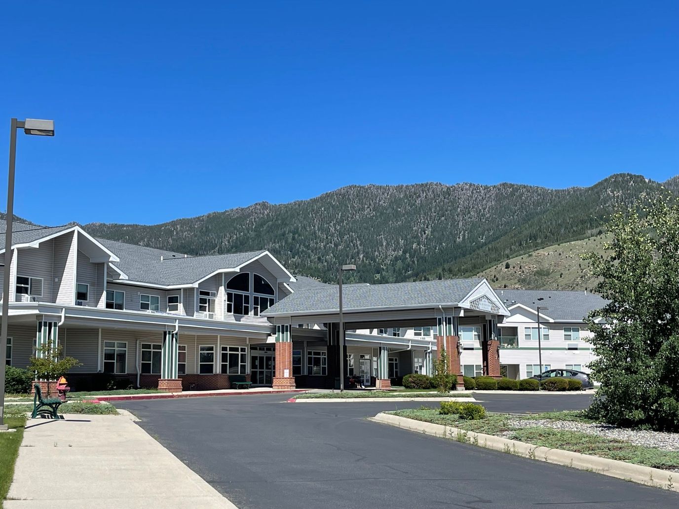 Exterior view of a senior living facility with mountains