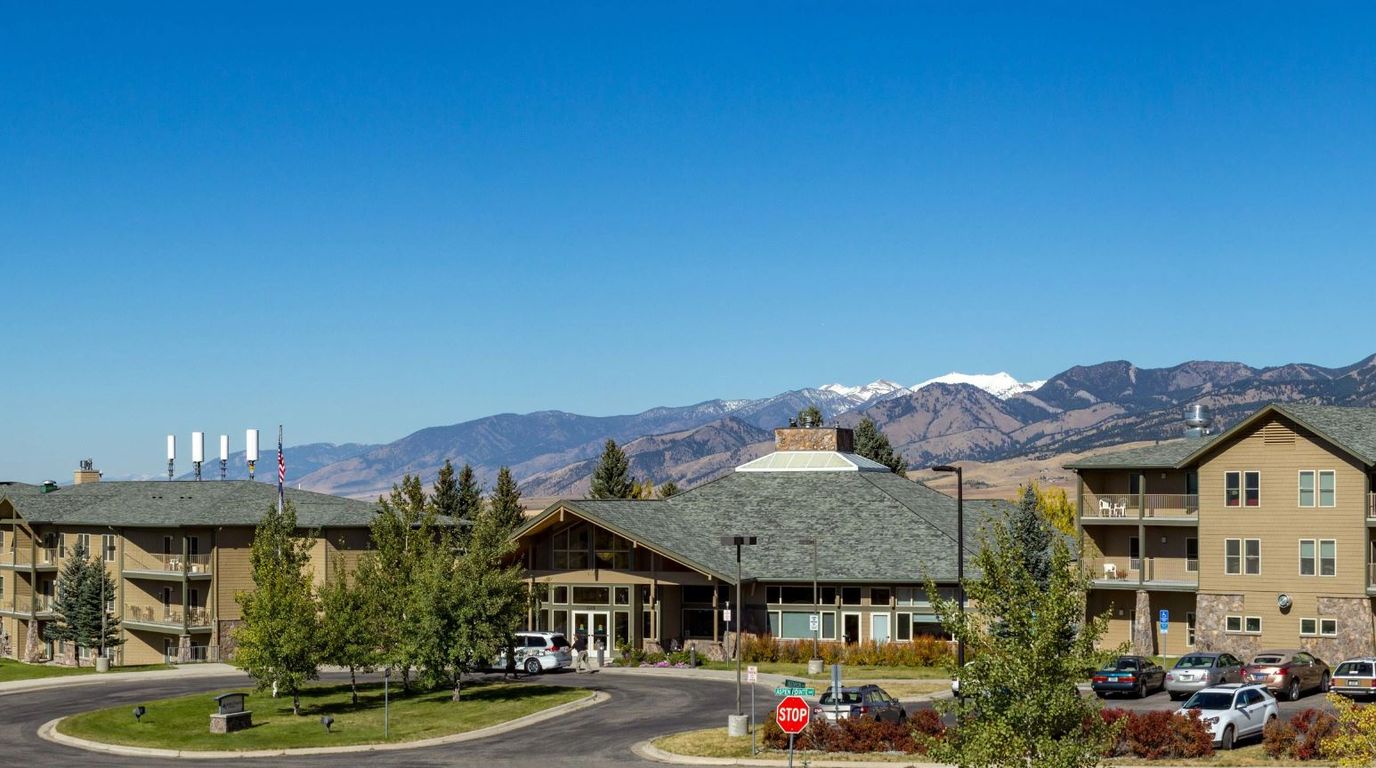 Exterior view of a senior living facility with mountains