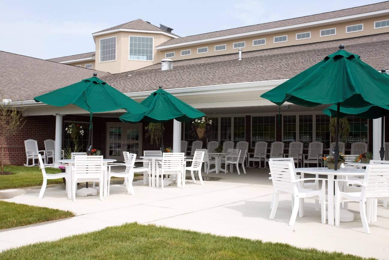 Outdoor patio area with white tables and green umbrellas