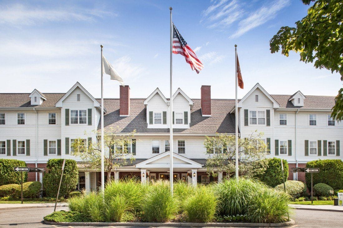 Exterior view of a senior living facility with flags