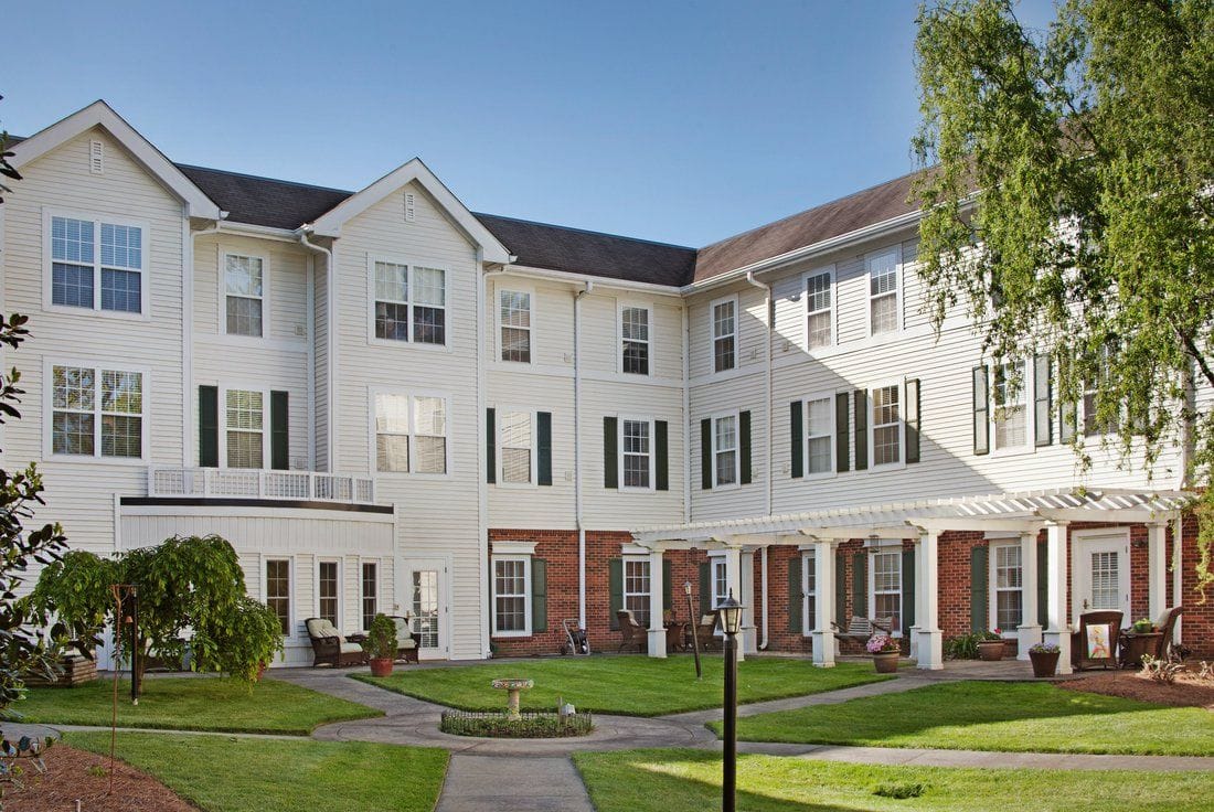 Exterior view of a senior living facility with green lawn