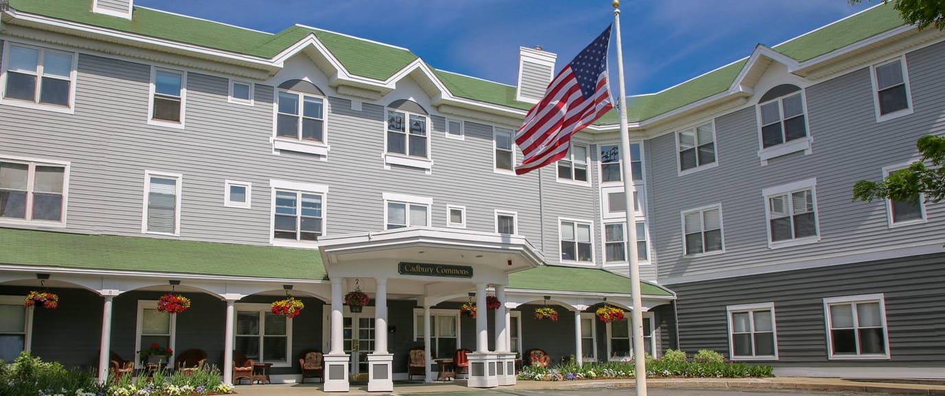 Exterior view of a senior living facility with flag