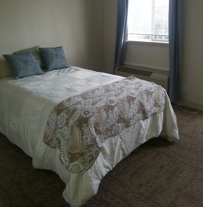 Cozy bedroom with a neatly made bed and natural light