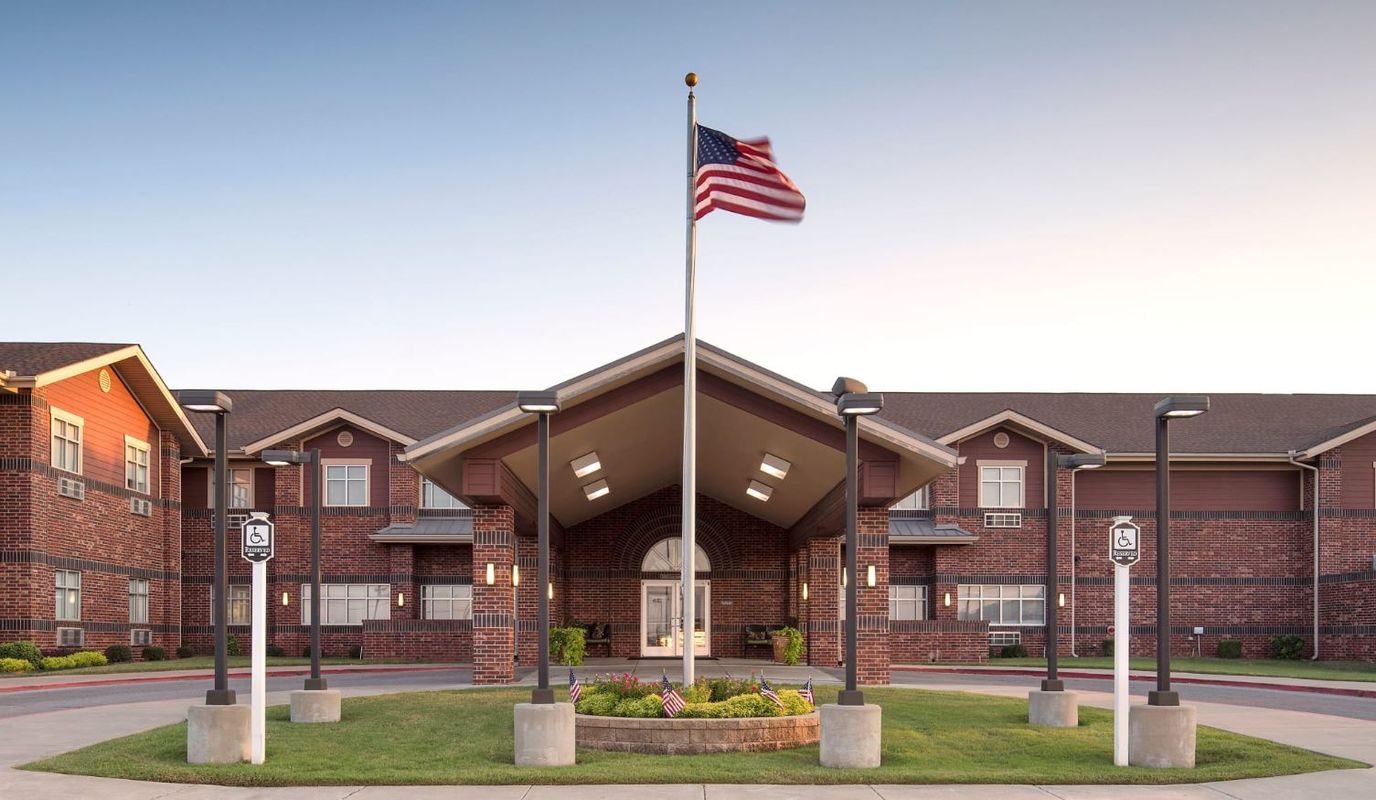 Exterior view of a senior living facility with flag