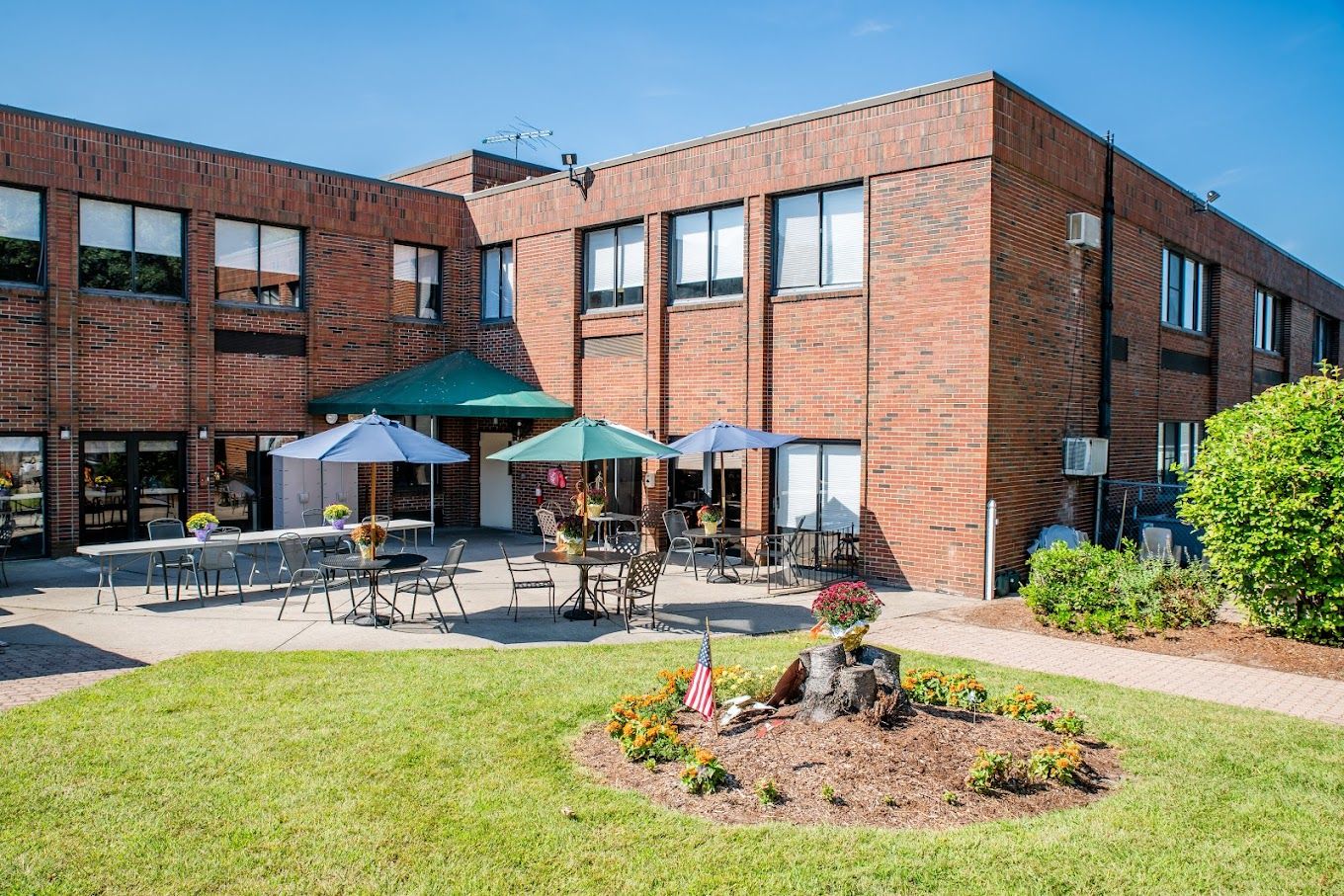 Exterior view of a nursing home with outdoor seating