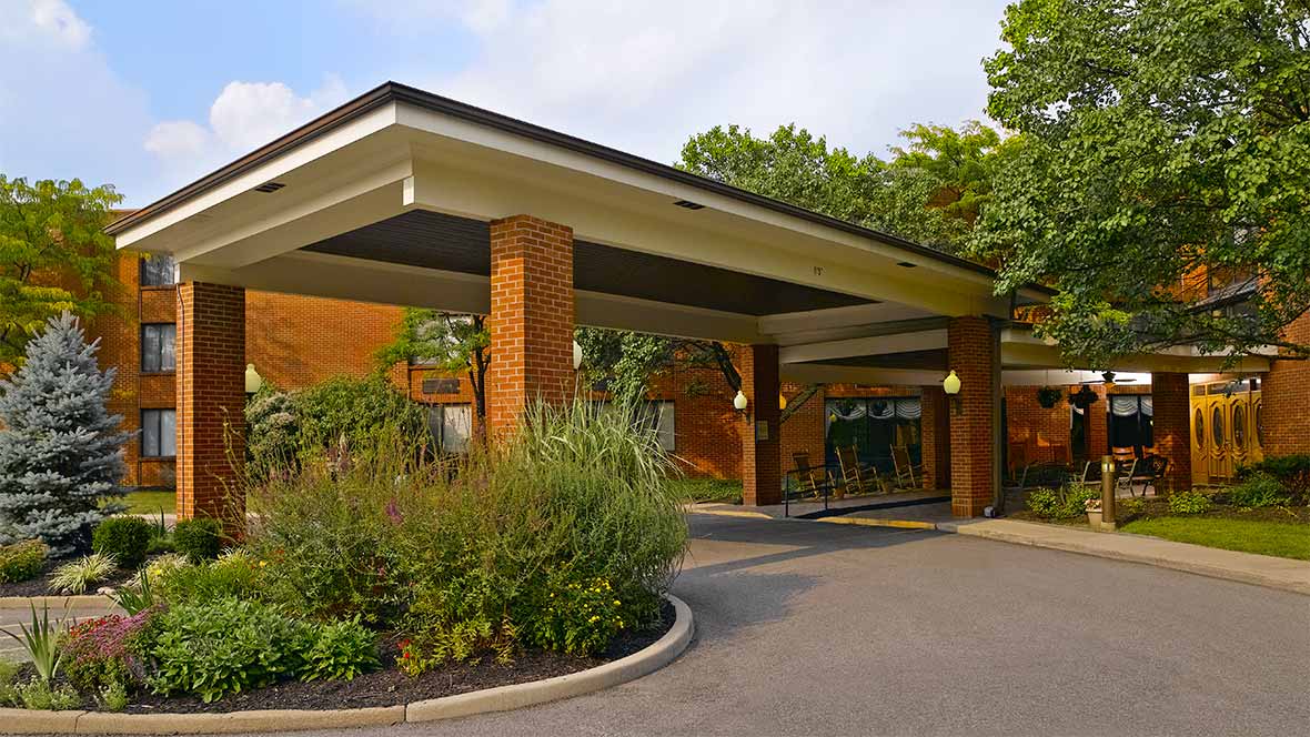Entrance of a senior living facility with landscaped gardens