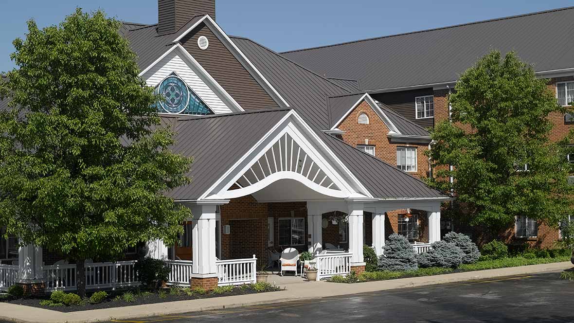 Front entrance of a senior living facility with landscaped gardens