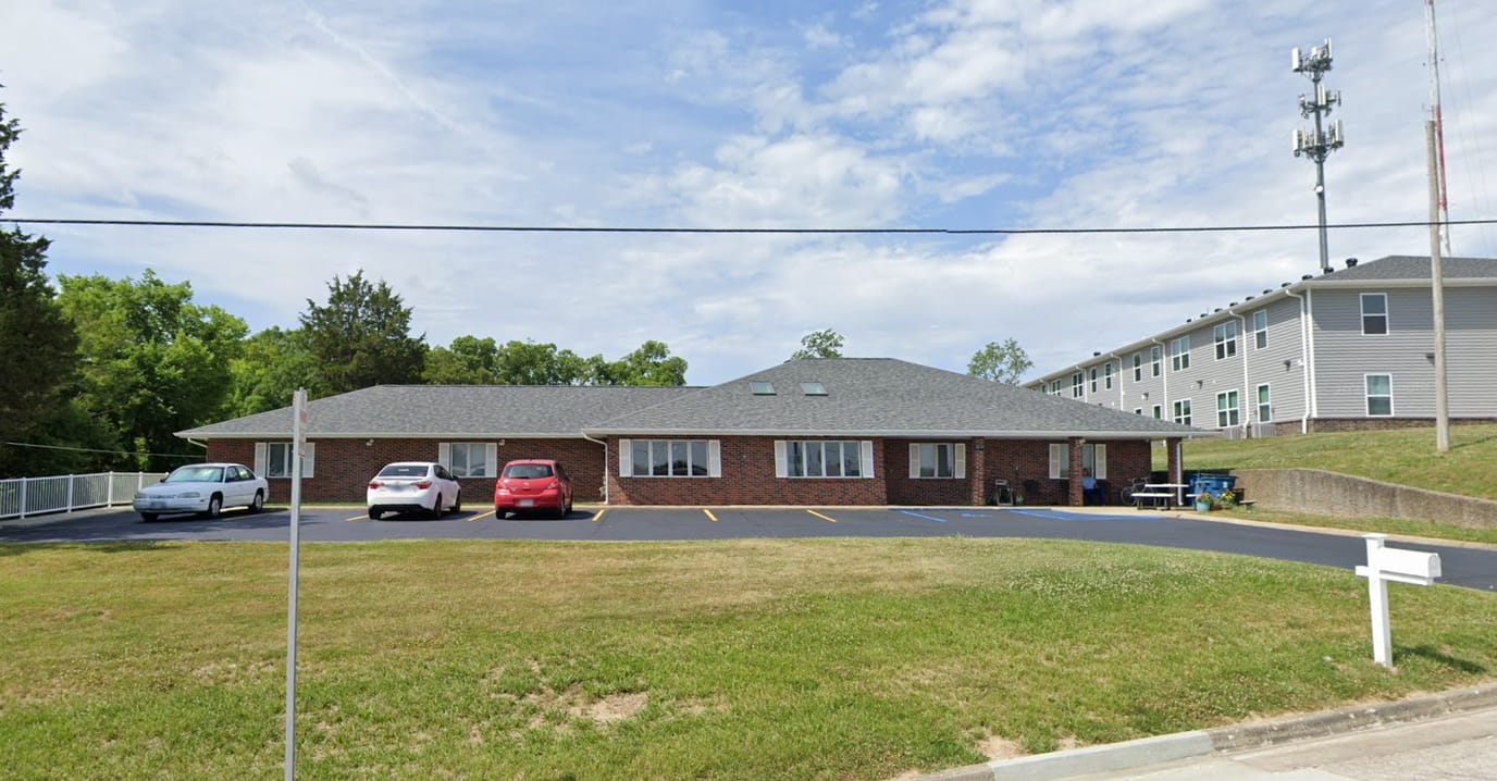Exterior view of Melody House with parking area