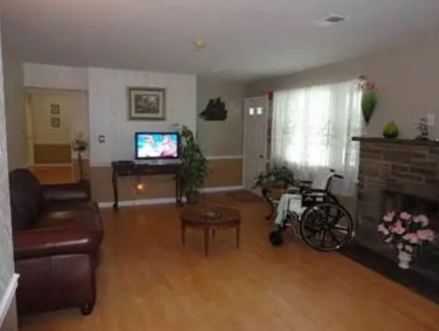 Cozy living room with a TV, seating, and a wheelchair.