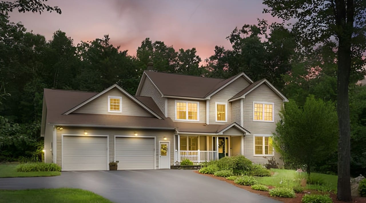 Exterior view of a home at dusk with illuminated windows