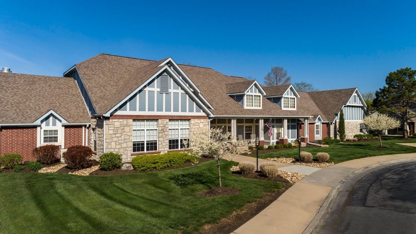 Exterior view of a senior living facility surrounded by gardens