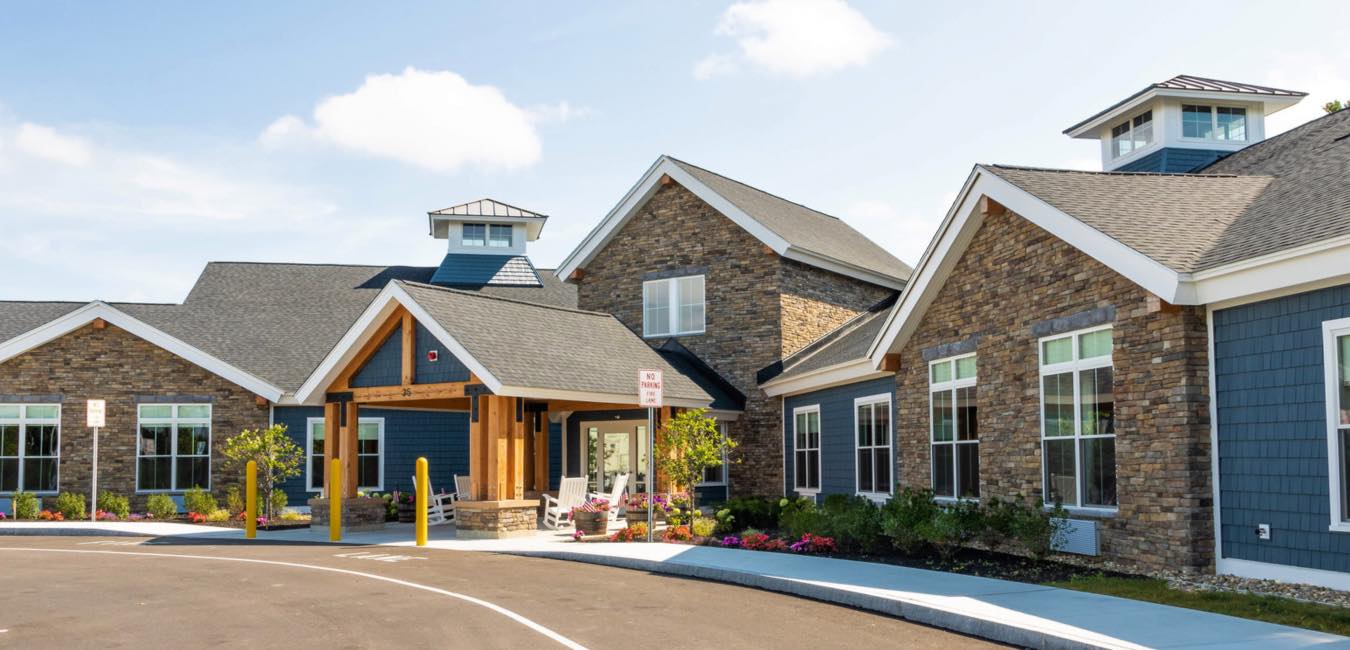 Exterior view of a senior living facility with landscaped entrance