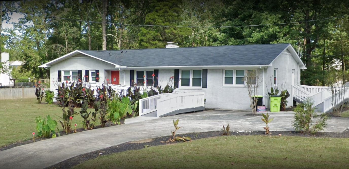 Exterior view of a residential care facility with ramps and garden