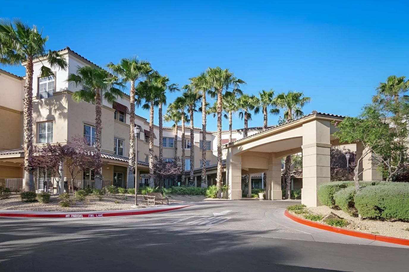 Building exterior of Sunrise of Henderson with palm trees