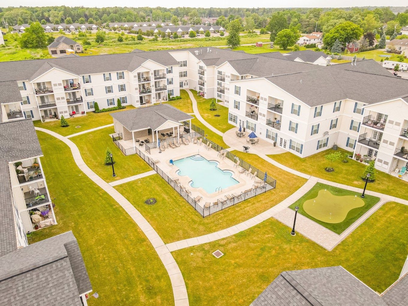 Aerial view of the facility with a pool and gardens