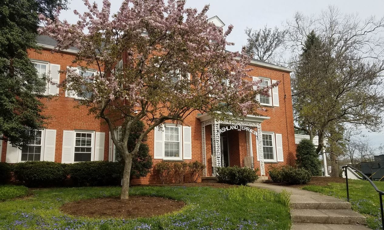 Exterior view of a senior living facility with flowering trees