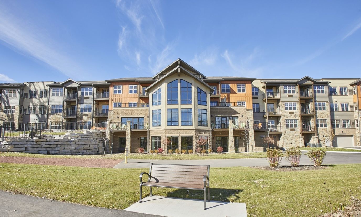 Exterior view of a senior living facility with gardens
