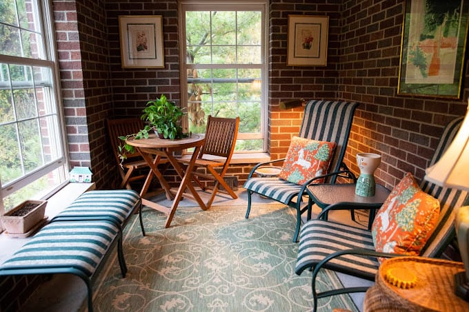 Cozy sunroom with seating and a small table at Wexner Heritage Village.