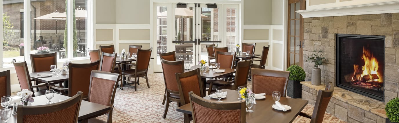 Bright dining room with tables and a fireplace