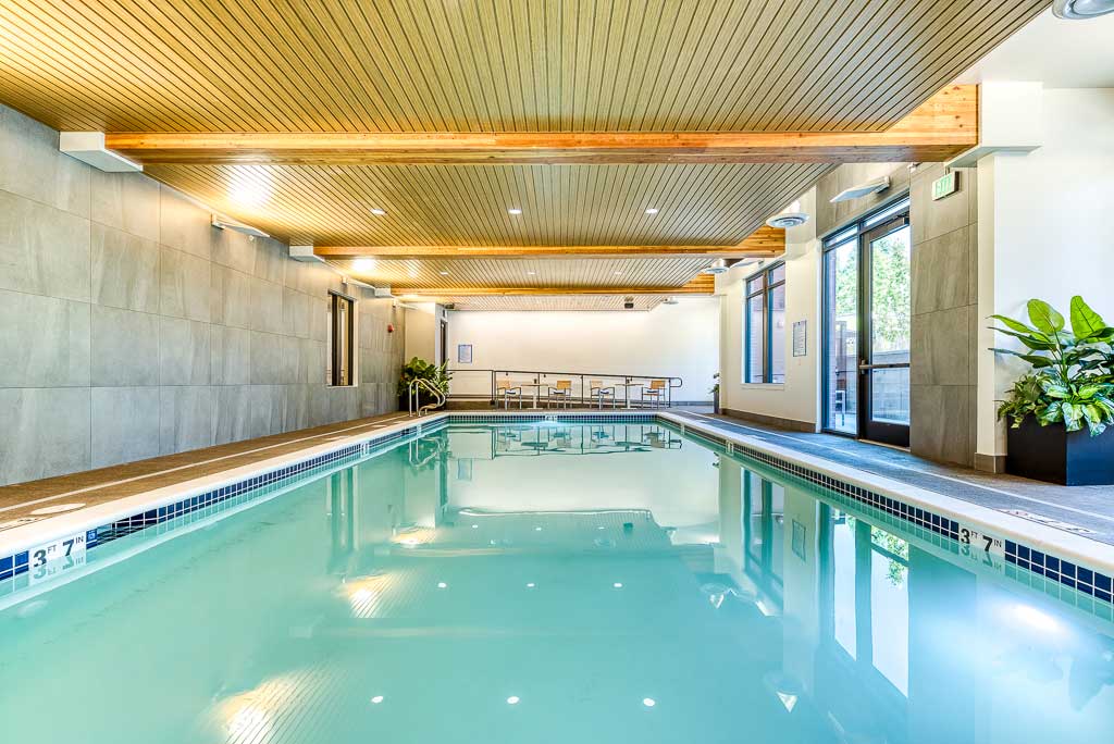 Indoor swimming pool area with a wooden ceiling