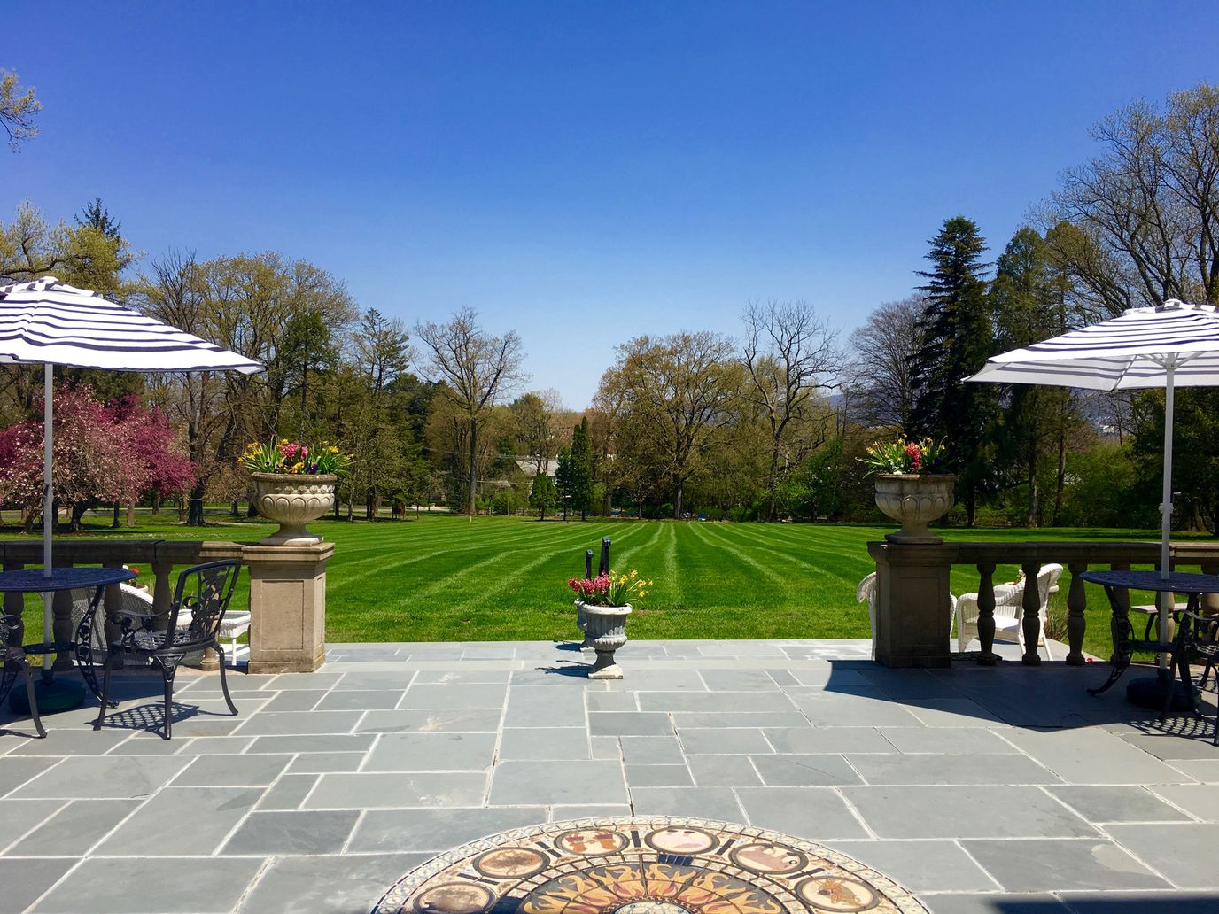 Outdoor patio with seating overlooking well-maintained lawn