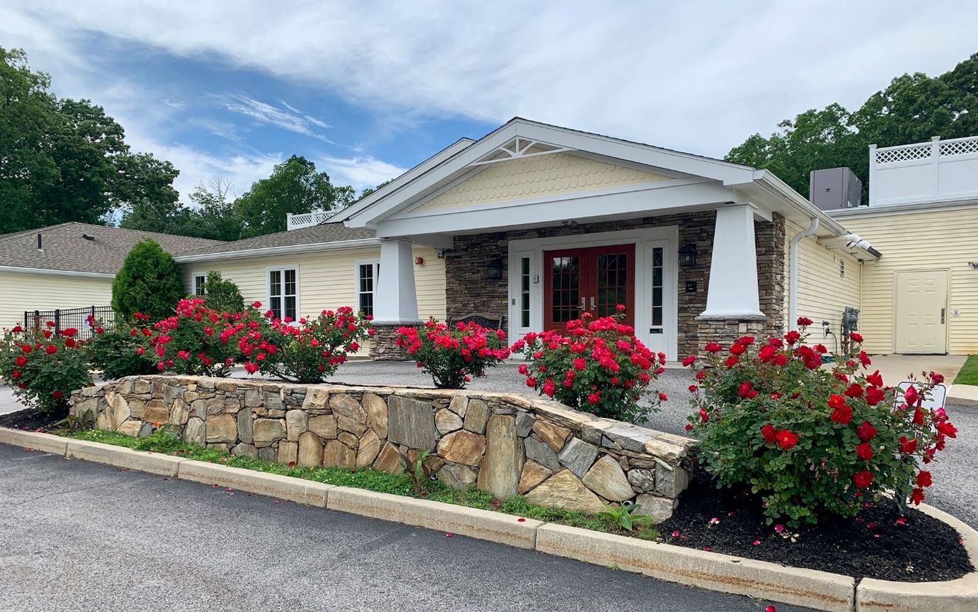 Exterior view of a senior living facility with flower beds