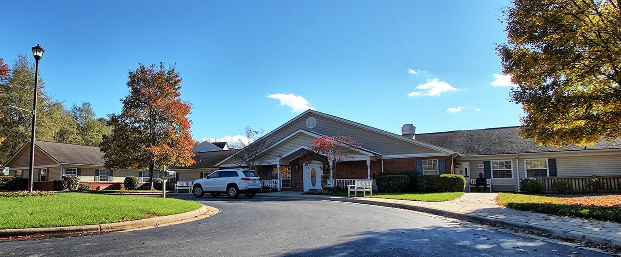 Exterior view of a senior living facility with gardens