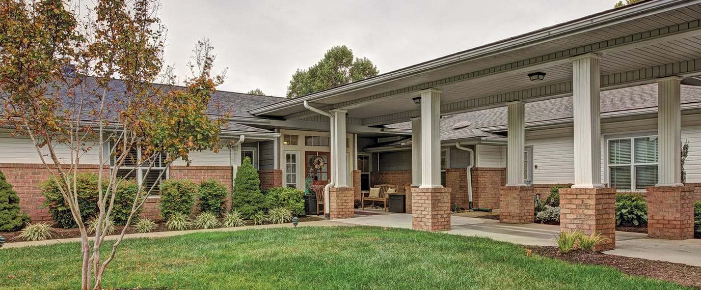 Entrance of a senior living facility with surrounding gardens