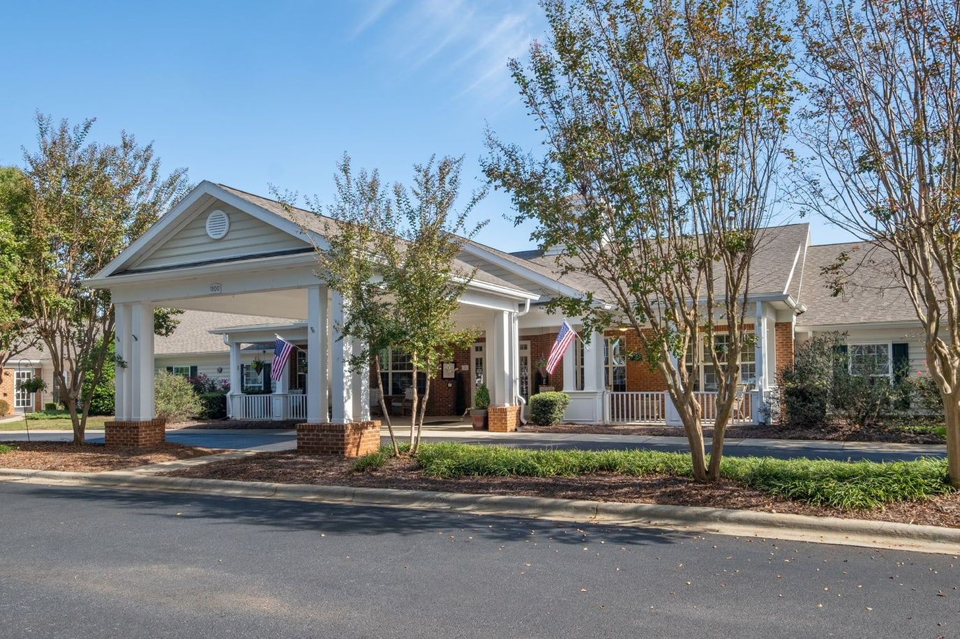 Exterior view of an assisted living facility with gardens
