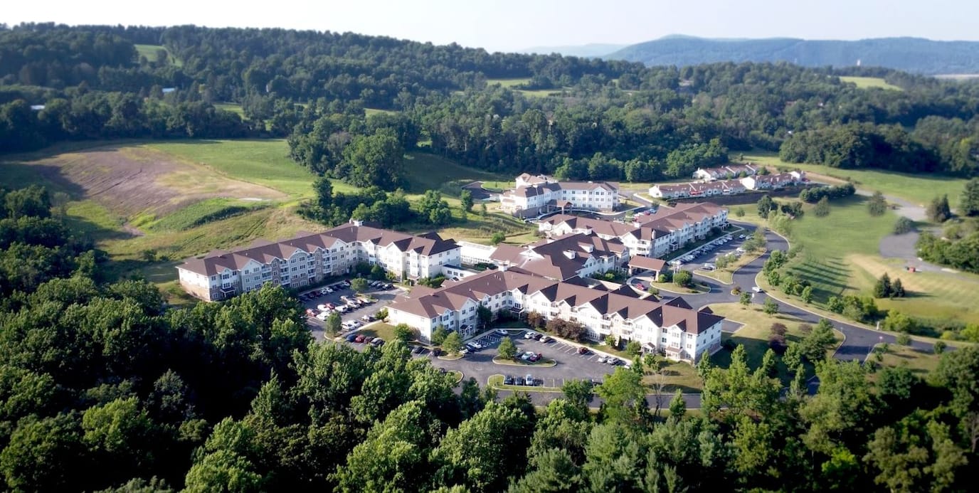 Aerial view of 'The Heritage of Green Hills' facility surrounded by greenery