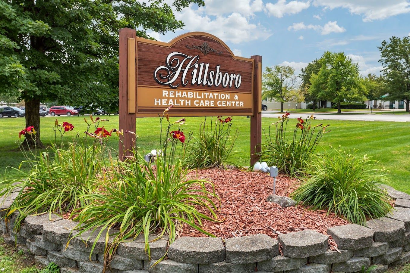 Sign for Hillsboro Rehabilitation & Health Care Center surrounded by flowers