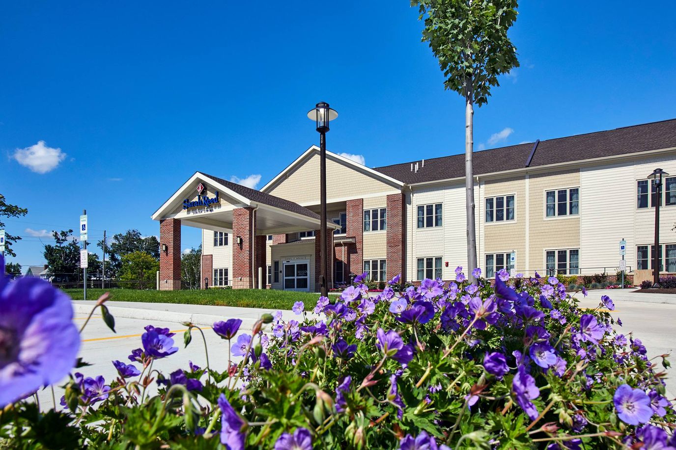 Exterior view of Sarah Reed Senior Living with flowers